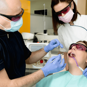 Dentist performing laser procedure on a patient