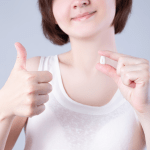 Woman satisfied following tooth extraction holding tooth