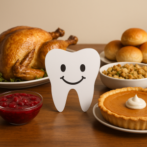 An illustrated tooth with a smile in the middle of a Thanksgiving feast on a brown wooden table